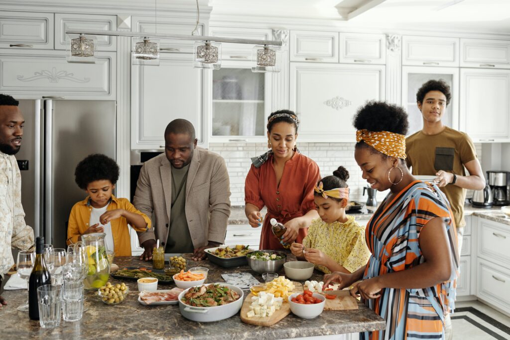 une famille cuisine ensemble, ils ont l'air heureux, ils semblent passer un bon moment