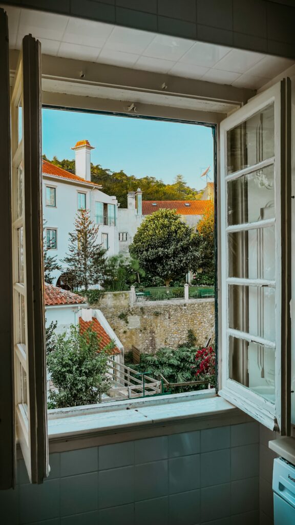 une fenêtre est ouverte sur l'exterieur, avec vue sur un petit village