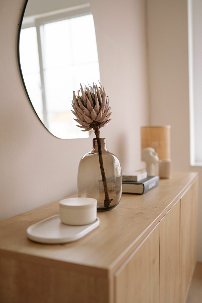 Commode en bois massif devant mur beige — le beige comme fond qui laisse de la place aux matières naturelles