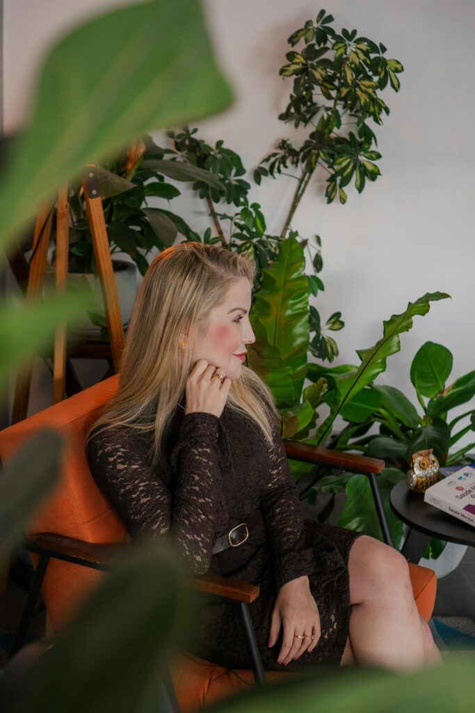 Femme pensive dans un salon épuré et lumineux, illustrant le lien entre psychologie de l'habitat et bien-être chez soi.